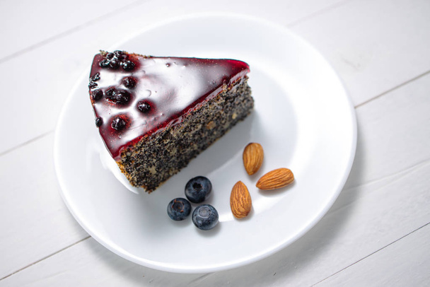 Cake with berry fruits, chia cereals and nuts isolated on wooden - Photo, Image