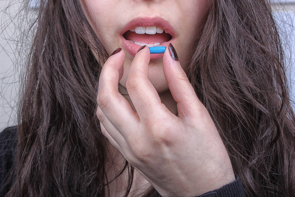 young woman who the pill in his mouth - Фото, зображення