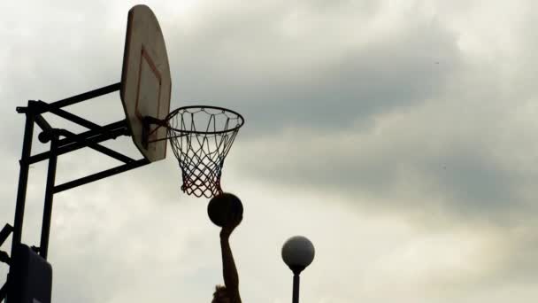 basketbalspeler gooien bal in hoepel op sportveld atleet gooien bal in ring outdoor basketbal score slow motion - Video