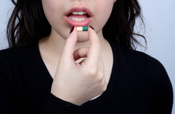 νεαρή γυναίκα που το χάπι στο στόμα του - Φωτογραφία, εικόνα