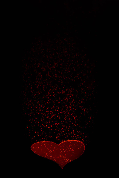 Card with a red heart on a black background for Valentine`s Day - Foto, imagen