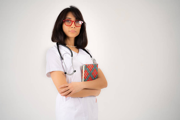 Młoda dziewczyna lekarz lub student stoi z folderu w rękach - Zdjęcie, obraz