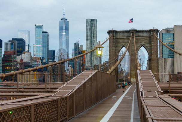 Mensen lopen in Brooklyn bridge op moment van de dag - Foto, afbeelding
