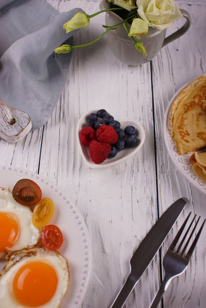 Aamiainen pannukakkuja ja paistettuja munia
 - Valokuva, kuva