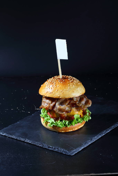Bacon burger on black background - Фото, изображение