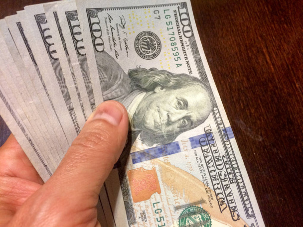 Stack of cash held in left hand - Photo, Image