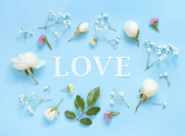 Çiçekler ve sözcük açık mavi arka planda aşk - Fotoğraf, Görsel
