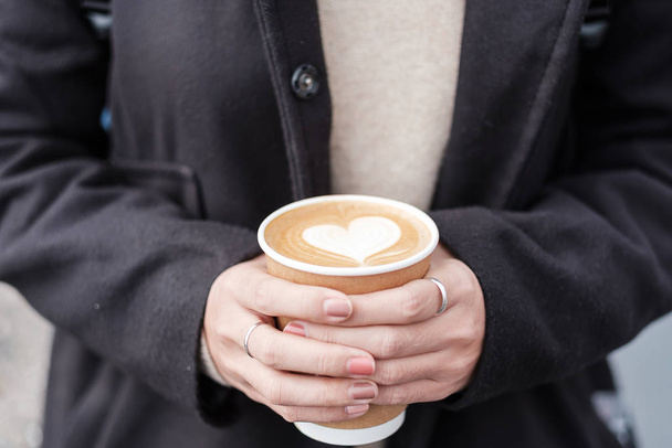 Kobieta ręce gospodarstwa Gorąca kawa papierowa filiżanka, kształt serca latte coff - Zdjęcie, obraz