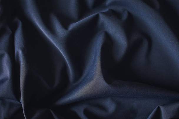 Tejido de lana azul oscuro plegado de cerca para el fondo
.  - Foto, imagen