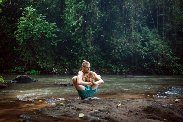 自然の中でヨガの練習と瞑想。川の近くで練習している男 - 写真・画像