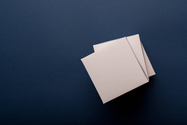 Stack of white cardboard boxes on a classic blue background - Foto, afbeelding