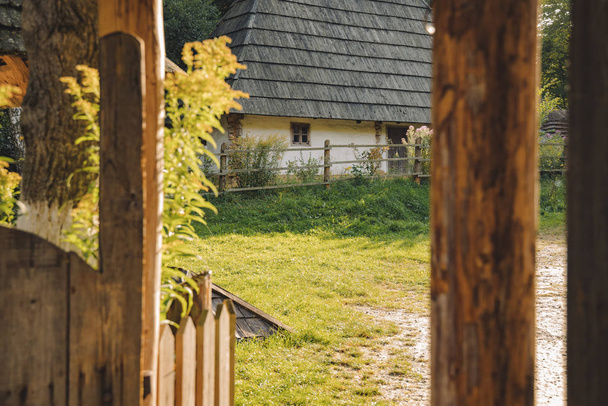 Ucrania tradicional casa rural fachada exterior pueblo punto de vista desde el porche de madera marco material trabajo en primavera tiempo soleado
 - Foto, Imagen