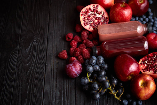 Mix of fresh red and black fruits. With botteled fresh juices - Photo, Image