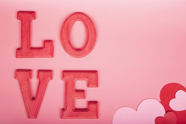 Pozvánka dopis se slovem Láska v fuxia dřeva na růžovém pozadí s kopírovacím prostorem - Fotografie, Obrázek