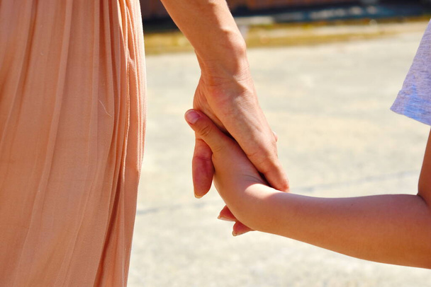 Taking care of children. Support of the child. Holding hands together - Φωτογραφία, εικόνα