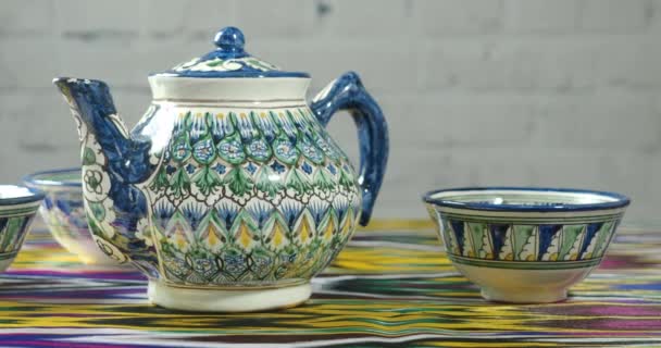 Tradycyjny uzbecki czajniczek pozostaje na tradycyjnym tekstyliów - chan atlas - Materiał filmowy, wideo