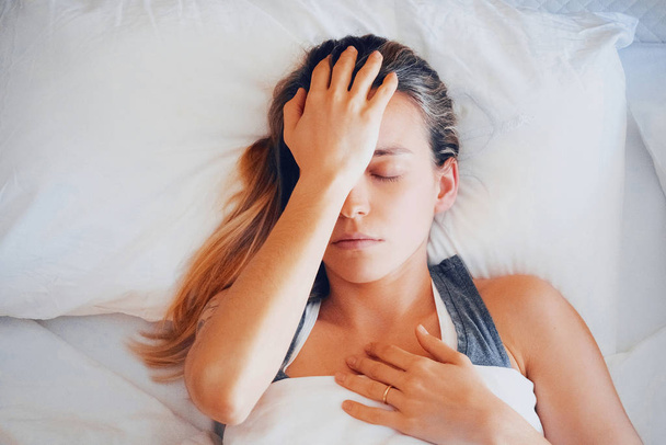 Szépség, fiatal nő fejfájással az ágyban - Fotó, kép