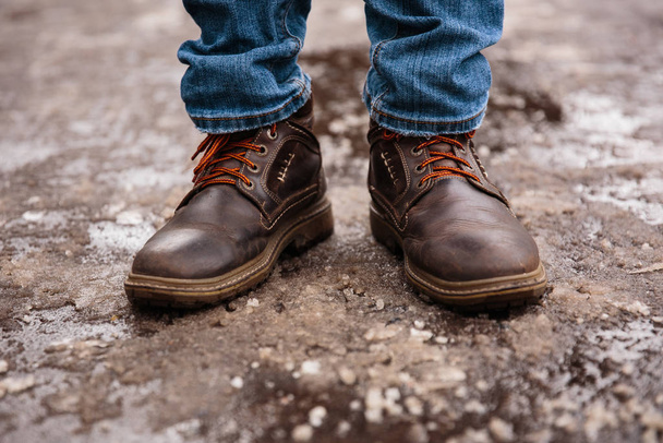 Men's winter boots on snow. Brown men's warm winter boots closeup - Zdjęcie, obraz