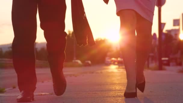 ANGOLO BASSO: Uomo e donna irriconoscibili con i tacchi alti che camminano verso il lavoro all'alba - Filmati, video