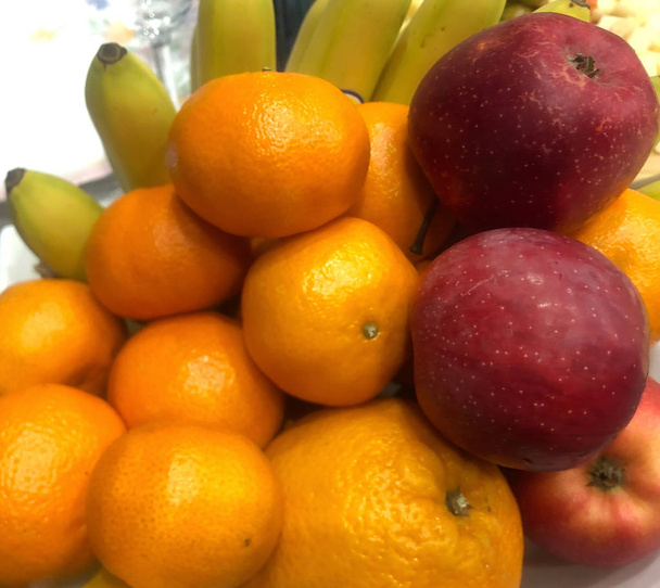 Mandarin, kırmızı elma ve muz tabakta. - Fotoğraf, Görsel