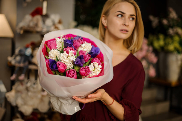 Blonde poses with bouquet of peonies and bellflowers - Fotó, kép