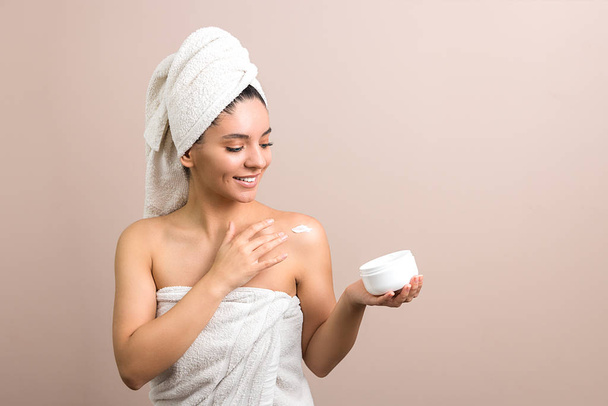 cheerful woman enjoying cream product after bath. white jar cream - Foto, Imagen