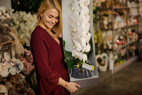 Hermosa mujer sosteniendo flor gigante en maceta
 - Foto, Imagen