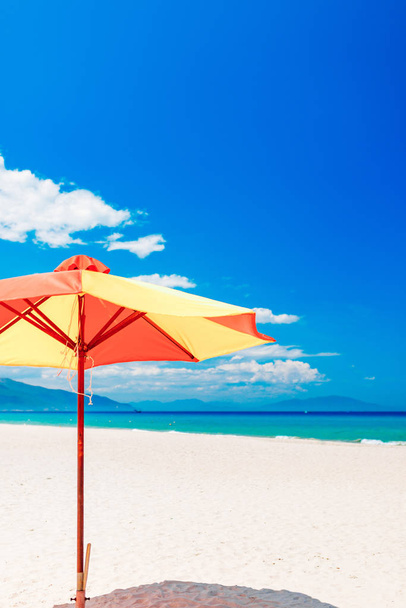 Empty white sand beach and parasol, blue sky - 写真・画像