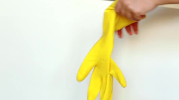 Aufräumen. Frauenhände tragen zur Reinigung gelbe Handschuhe. isoliert auf weißem Hintergrund. - Filmmaterial, Video