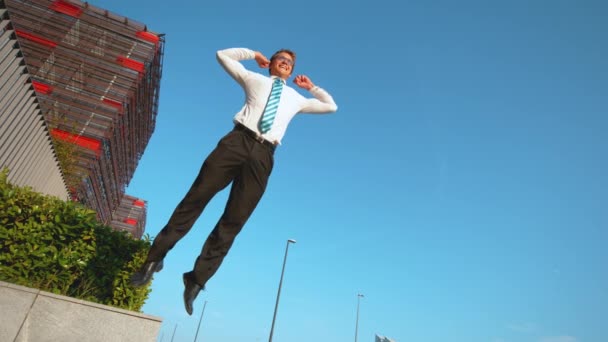 LOW ANGLE:成功した会議後、陸上ビジネスマンは空中で高くジャンプします. - 映像、動画
