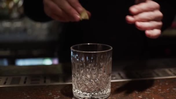 Process of making alcohol cocktail, adding lemon in glass, slow motion, shallow depth of field - Video, Çekim