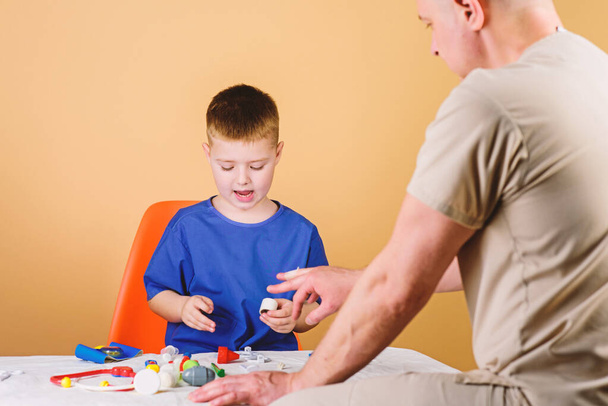 Hospital worker. Medical service. Analysis laboratory. Kid little doctor sit table medical tools. Health care. Pediatrician concept. Boy cute child and his father doctor. Medical examination - Photo, image