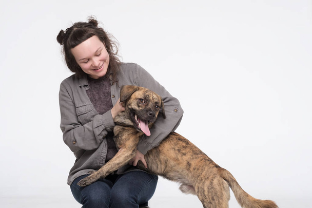 若い可愛い女が犬を抱きしめる。ペットと人間の友情 - 写真・画像