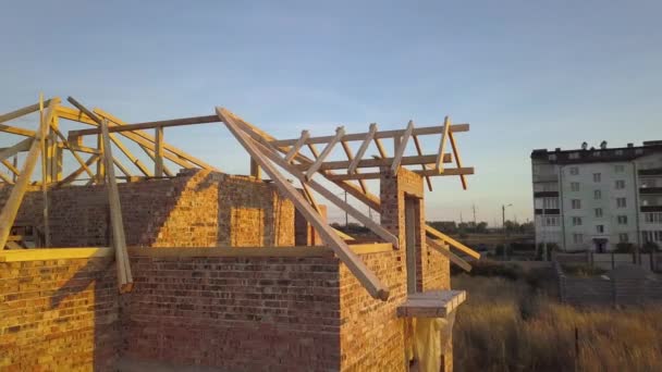 Veduta aerea della casa in mattoni non finiti con struttura del tetto in legno in costruzione. - Filmati, video
