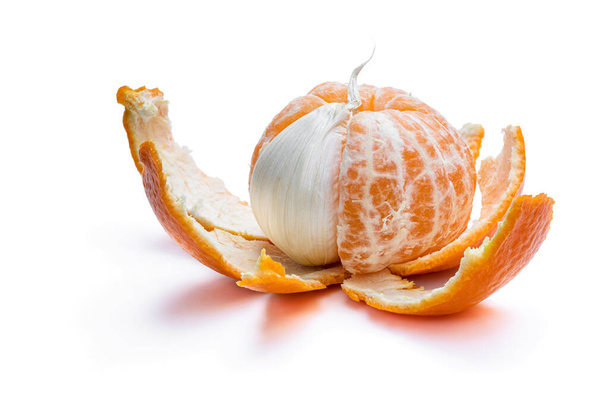 Concept of artificial fruit. Peeled mandarin with clove of garlic.  - Photo, Image