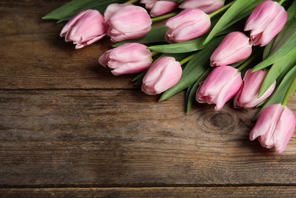 Beautiful pink spring tulips on wooden background. Space for tex - Fotó, kép