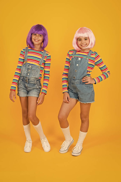 Anime fan. Cheerful friends in colorful wigs. Anime cosplay party concept. Animation style characterized colorful graphics vibrant characters fantastical themes. Anime convention. Happy little girls - Фото, изображение
