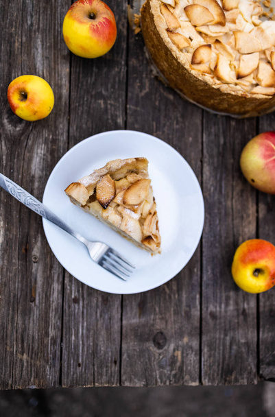 amerikanischer Apfel zwetajewski geleerte offene Tortenstück auf einem Teller, in Großaufnahme, auf einem dunklen Holzgrund. flache Lage - Foto, Bild