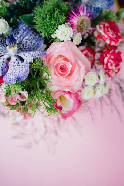 ピンクを基調とした丸い箱の中に、春の花々、バラ、蘭などを散りばめたスタイリッシュな繊細な花束。スペースのコピー - 写真・画像