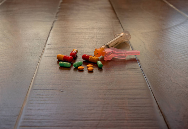 Siringa con pillole idromorfone oppioidi su sfondo di legno. Concetto sanitario e medico - concetto di dipendenza
 - Foto, immagini