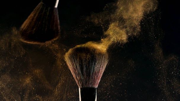 Two Soft cosmetic brushes release a cloud of colored smoke from bright eyeshadow and powder, - Fotó, kép