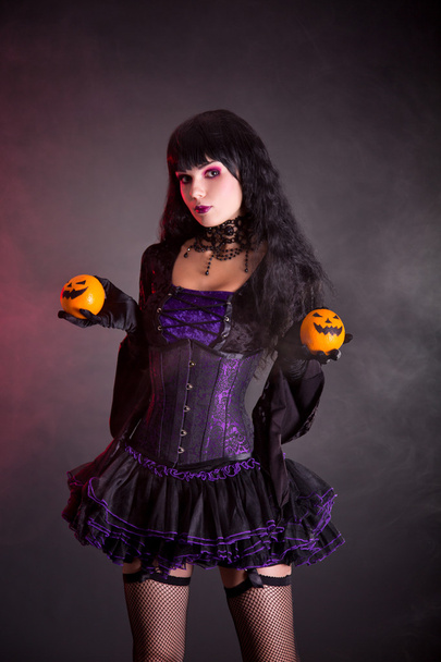 Pretty witch with Halloween styled oranges - Фото, изображение