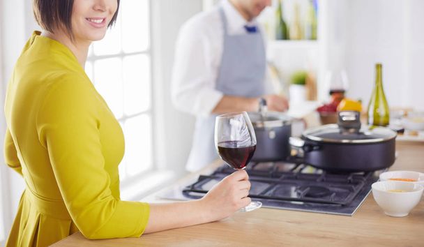Attractive couple in love cooking and opens the wine in the kitchen while they cook dinner for a romantic evening - Foto, Bild