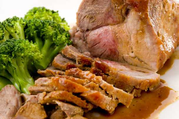 Roasted pork with sauce and broccoli on white plate - Photo, Image