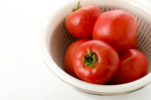 Ripe red Tomatoes in colander with Stainless steel bowl on white background - Photo, Image