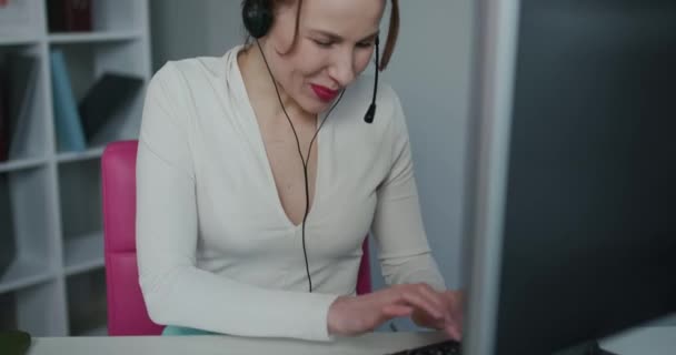 Woman customer care support service agent call center operator in wireless headset talk consult online client using computer solving complaints on helpline or sell services in telesales office - Footage, Video