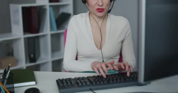 パソコンを使用してヘッドセットの携帯電話事業者をサポートします。コールセンターで働くエージェント女性の笑顔オフィスで働く - 映像、動画