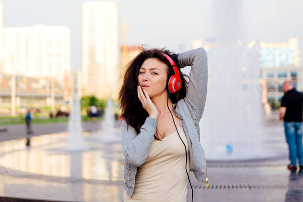 Luisteren naar muziek streaming met hoofdtelefoon en het maken van grappige gezicht meisje. - Foto, afbeelding
