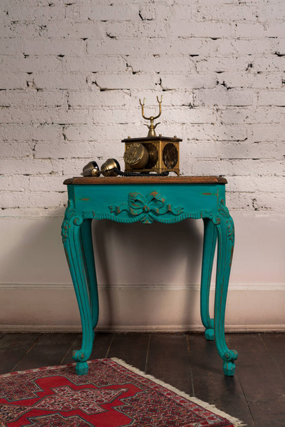 Mesa de madeira vintage verde e telefone dourado velho conjunto
 - Foto, Imagem