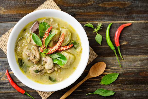 Thai green curry chicken in bowl on wooden background, Thai food, top view - Photo, Image